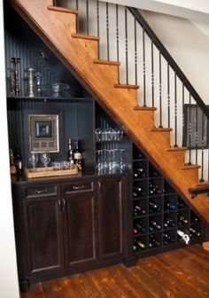 a wine rack under the stairs in a home