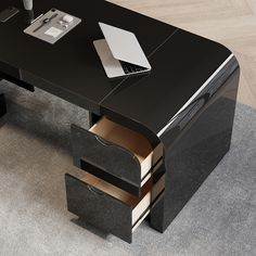 a black desk with drawers and a laptop on it's side, next to a gray rug