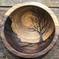 a wooden bowl with a tree painted on it