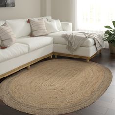 a living room with a white couch and large rug on the floor in front of a window