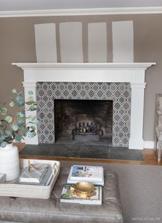 a living room with a fire place in the middle and books on the coffee table