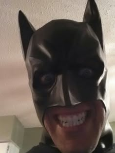 a man wearing a batman mask and smiling