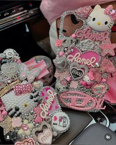 two hello kitty cell phones are sitting next to each other on a table with pink and silver accessories