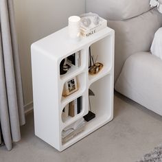 a white shelf with books and magazines on it