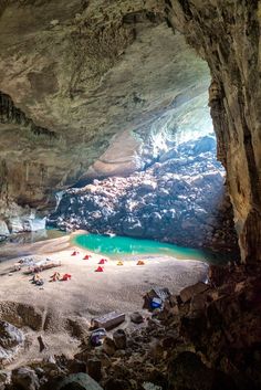 a cave filled with lots of water and people laying on the ground next to it