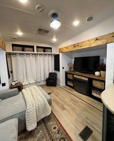 a living room filled with furniture and a flat screen tv on top of a wooden floor