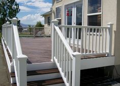 a porch with white railing and wooden steps