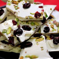 there are many pieces of white chocolate with nuts and dried cherries on the top