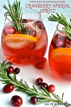 two glasses filled with cranberry aperoli spritz and rosemary garnish