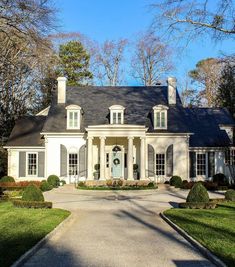 a large white house sitting on top of a lush green field