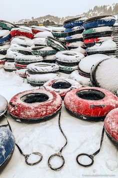 many snow covered boats are sitting in the snow on top of each other with chains attached to them