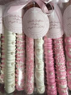 some pink and white toothbrushes are on display in a box with ribbons around them