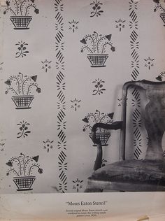 an old chair sitting in front of a wall paper with flowers and vines on it