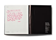 an open book with pink writing on it's cover and black paper in the middle