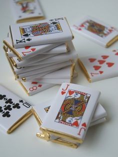 several playing cards are stacked on top of each other with gold trimmings and white paper