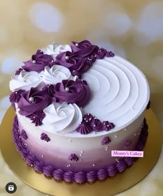 a white and purple cake with flowers on top