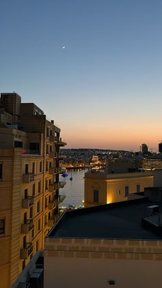 the city skyline is lit up at night, as seen from an apartment building rooftop