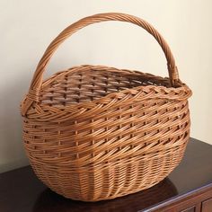 A real beauty, this rustic mid-20th century market basket features intricate handwoven designs, a braided rim, and French randing at the bottom. It is a sturdy, tall, and deep basket, making it perfect for carrying larger fruits and vegetables, as well as wine and other bottles. Also doubles as a lovely display piece.  Basket interior measures roughly 15” (w) x 9”(d) x 10” (h). Basketry Products, Antique Wicker Basket, Weaving Bamboo Basket, Farmouse Harvesting Basket, Handmade Basket-shaped Straw Rattan Bag, Chinese Wicker Basket, Market Basket, Willow Weaving, Basket Making