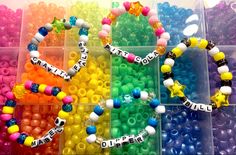 several different colored beads in plastic containers with name bracelets on each beaded strand