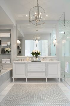 a large bathroom with two sinks and a chandelier