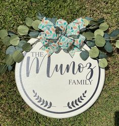 a sign that says the mums family with a bow on it sitting in the grass