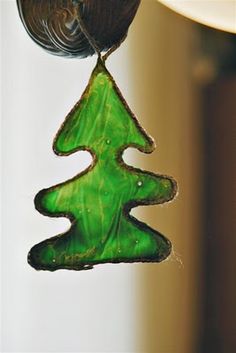 a green glass christmas tree hanging from a hook