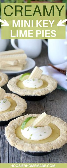 three small pies with whipped cream and lime on top, sitting on a wooden table