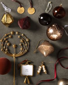 many different ornaments are arranged on a table top with ribbons and tags attached to them