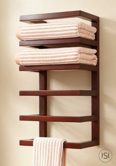 a towel rack with three towels hanging on it's sides and two folded ones in the middle