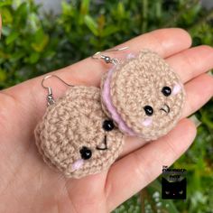 two small crocheted teddy bears sitting on top of each other in someone's hand