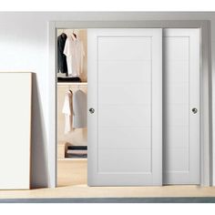 an open closet with two white doors and clothes on hangers next to it in a room