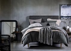 a bedroom with gray walls and grey bedding