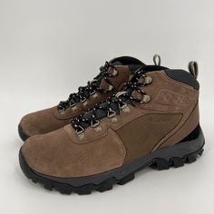 a pair of brown hiking boots with black laces on the outstretches