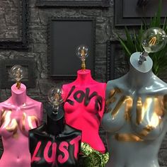 three mannequins are standing next to each other in front of a brick wall