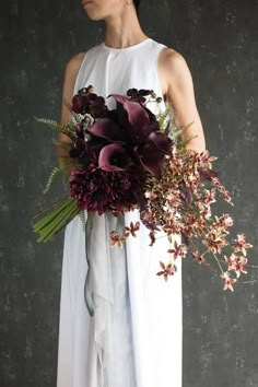 a woman holding a bouquet of flowers in her hands