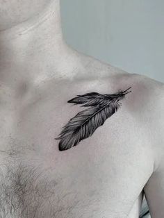 a man's chest with a black and white feather tattoo on the left side