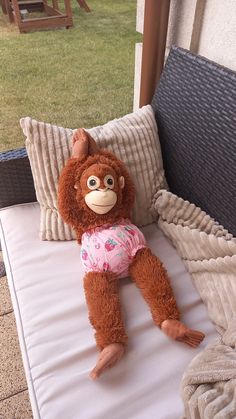 a stuffed animal sitting on top of a white pillow next to a window sill