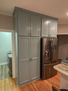 an empty kitchen with stainless steel appliances and wood flooring is pictured in this image