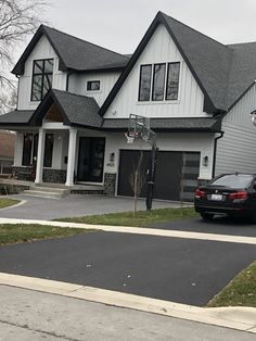 a car parked in front of a house with a basketball hoop on it's roof