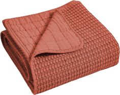 an orange quilted blanket folded on top of each other