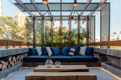 an outdoor living area with blue couches and wooden tables