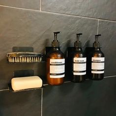 three soap dispensers are hanging on the wall