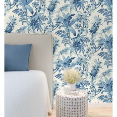 a blue and white floral wallpaper in a bedroom with a small round table next to it