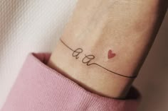 a woman's wrist tattoo with the word love written in cursive writing