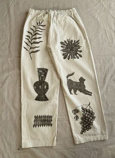 a pair of white pants with black designs on them