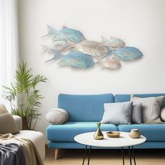 a living room with a blue couch and white table in front of a painting on the wall