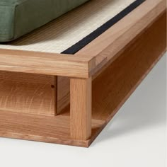 a close up of a bed frame with a green mattress on it's side