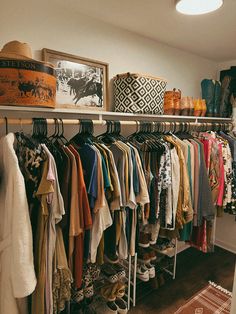 a closet filled with lots of different types of clothes and shoes on shelves next to a lamp