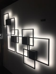 a white wall with several square and rectangle lights on it's sides, all lit up