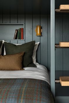 a bed with bookshelves and pillows on it